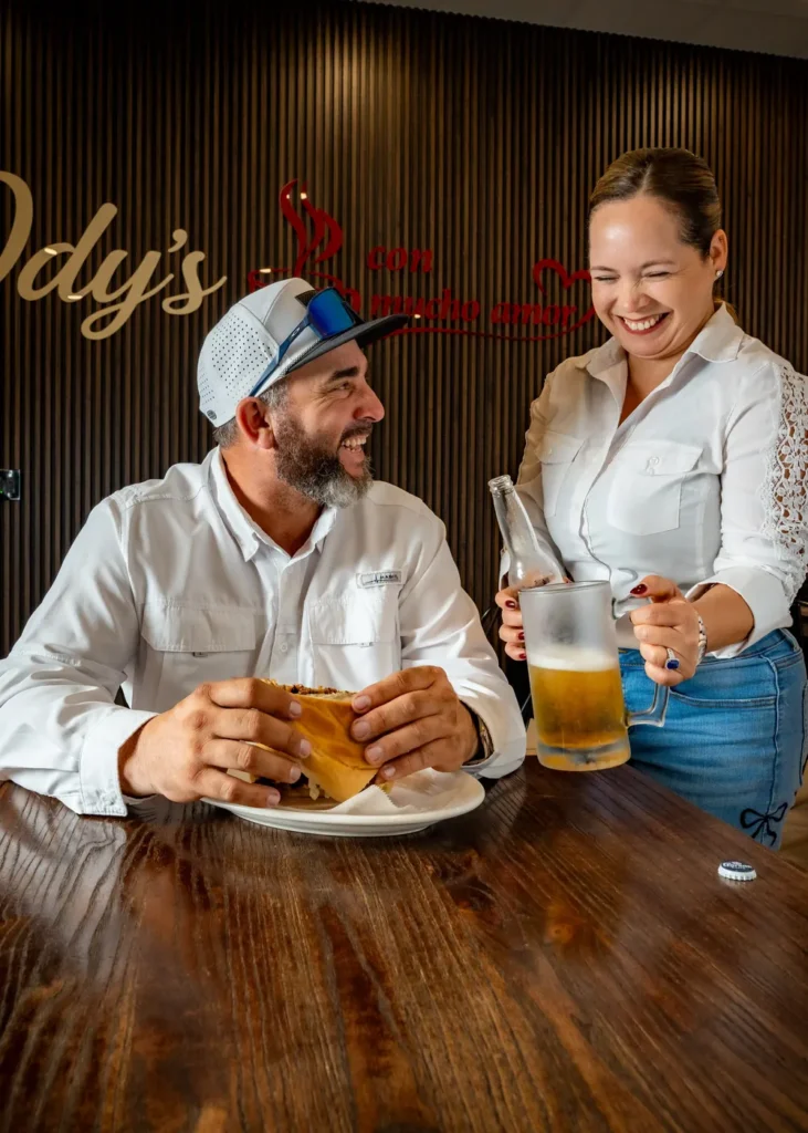 Guest enjoying a Cuban sandwich and a cold beer at Ody's Cuban Cafe in Davie
