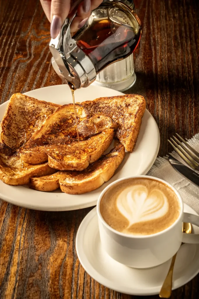 Cuban French toast drizzled with syrup next to a cafÃ© con leche at Ody's Cuban Cafe