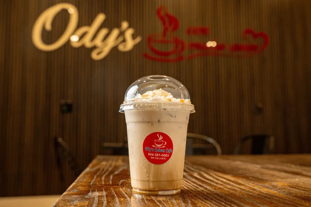 Iced Cuban coffee with whipped cream in an Ody's Cuban Cafe cup
